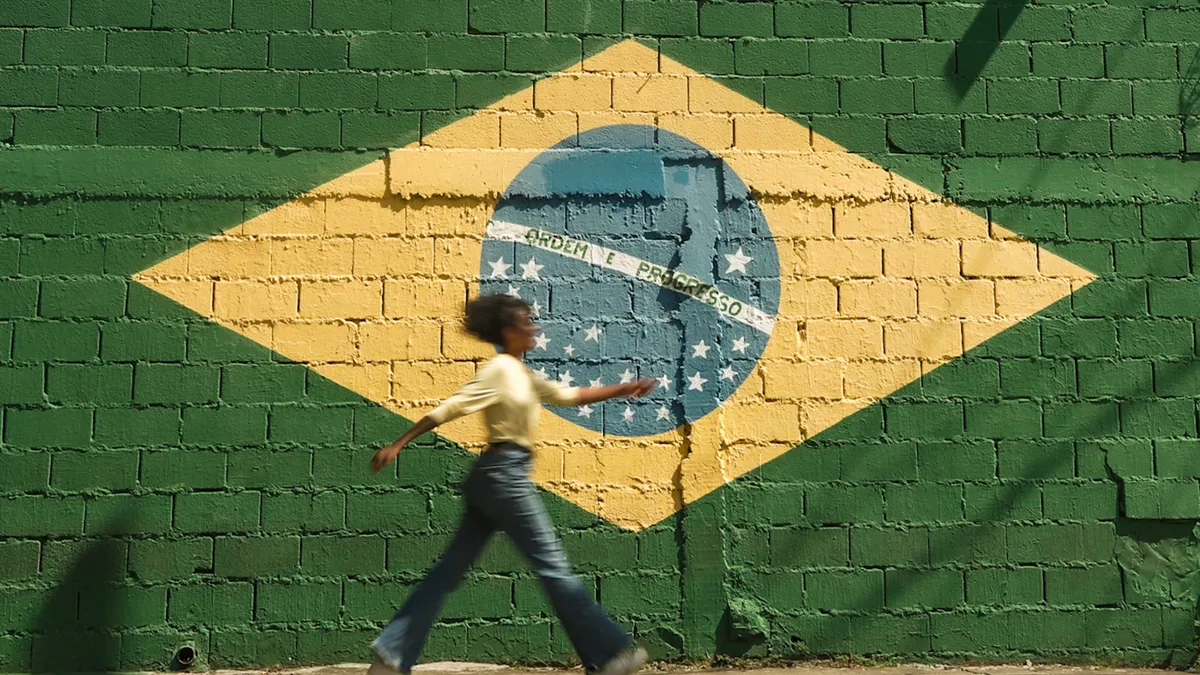 Girl Walking on Street with Brazilian Flag on Wall